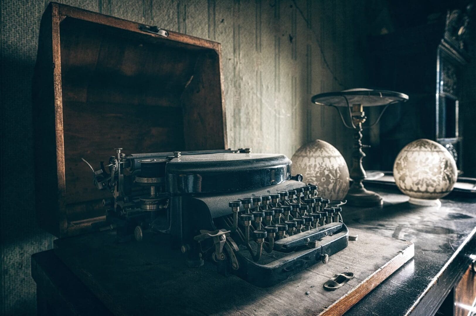 A table with an old typewriter and a wooden box.
