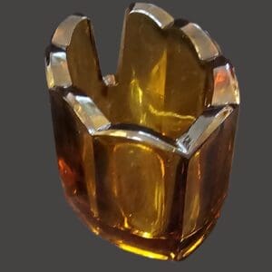 A translucent amber glass sculpture with a geometric design.