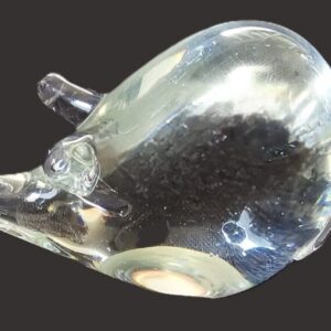 A glass mouse figurine with intricate details on a dark background.