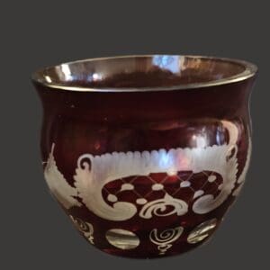 A small, dark brown ceramic cup with white decorative patterns.