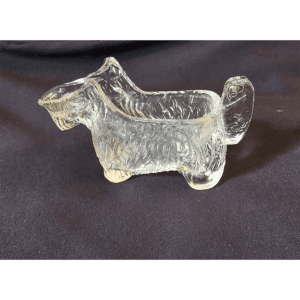 A small glass figurine shaped like a dog with a curled tail.