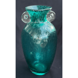 A tall, translucent turquoise glass vase with circular handles on each side.