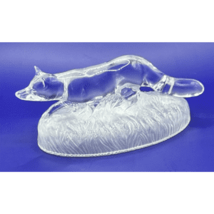 A clear glass fox figurine on a textured base.