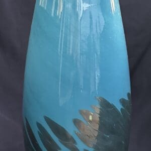 Tall blue vase with abstract dark accents.
