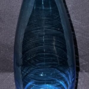 Close-up of a dark glass bottle with light reflections.