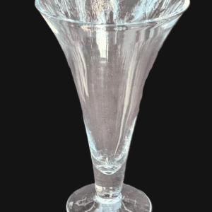 A clear, elegantly shaped glass vase with a flared top against a black background.