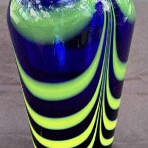 Close-up of a colorful glass vase with blue and yellow-green swirls.
