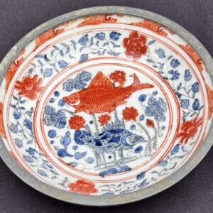 Decorative porcelain plate with red and blue floral and bird motifs.