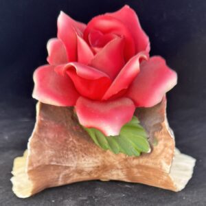 A pink rose made of icing on a pastry base.