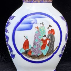 Porcelain vase with a detailed traditional Asian scene in blue and red hues.