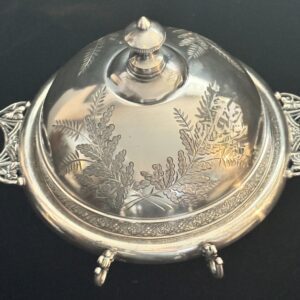 Ornate silver serving dish with intricate floral engravings and decorative handles.
