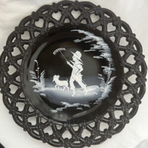 Decorative plate with intricate lace-like border and a pastoral scene in the center.