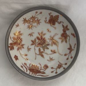 Decorative ceramic plate with intricate floral and bird designs in warm brown tones.