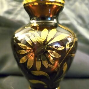Ornate glass vase with golden floral design.