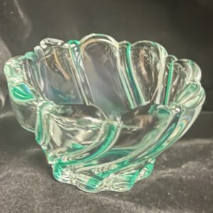 A clear glass bowl with green accents and a wavy design.